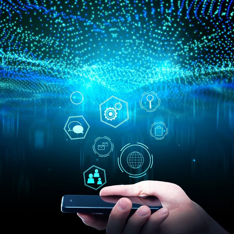 Ein Handy wird in der Hand gehalten. In der Luft schweben Informations- und Datensymbole.