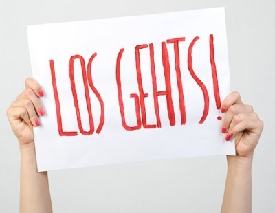 Zwei Hände halten einen weißes Plakat mit der Aufschrift "Los geht’s!" in die Luft.